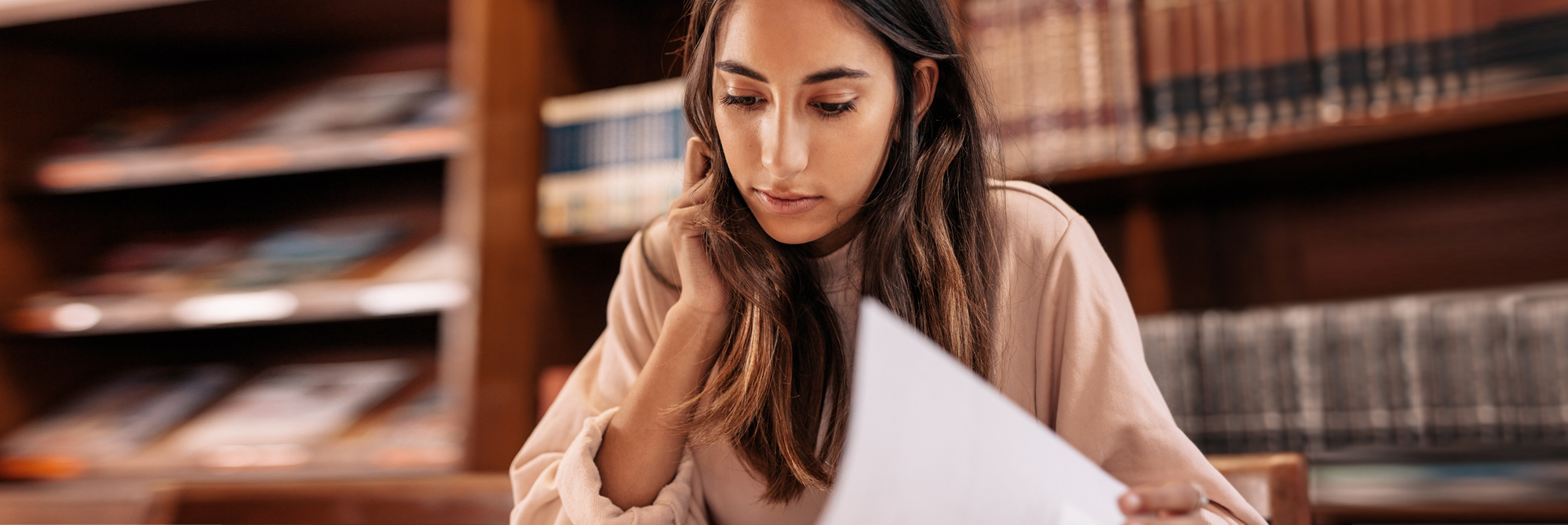 Young student reading in the library proven techniques to get ready for IBDP exams.