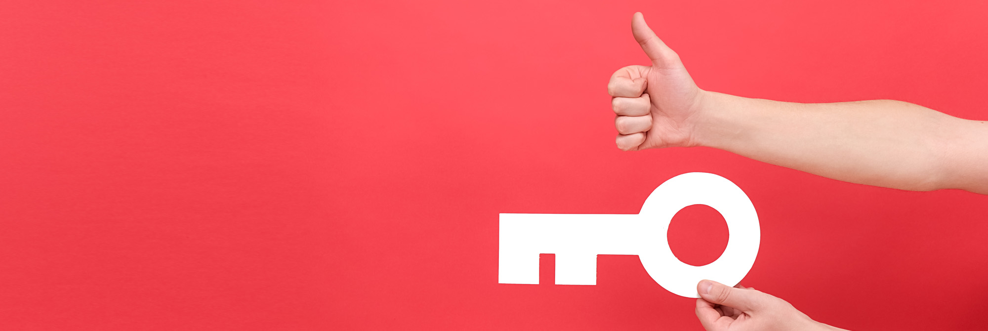 Close up of male hands holding big white key and showing thumb up.